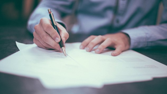 En man som sitter vid ett bord med papper framför sig och skriver anteckningar. Bild: Pixabay.