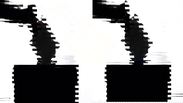 En person som lägger ner en valsedel i en box. Bild: Unsplash. 