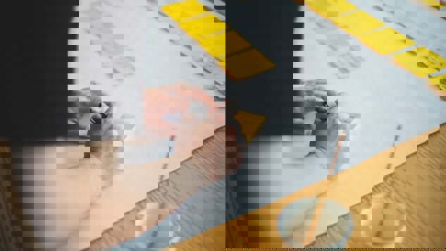 En person som skriver på gula post-it lappar. Bild: Unsplash.