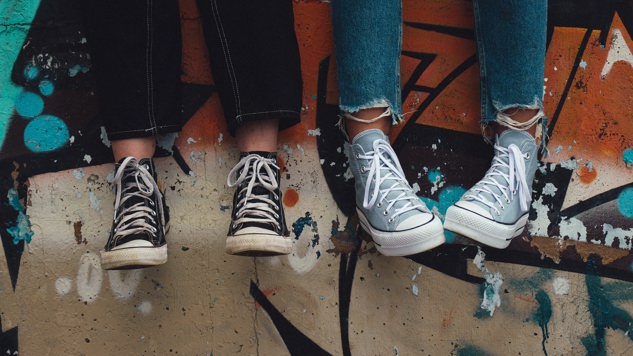 Two people sitting on a graffiti wall. Picture: Aedrian/Unsplash.