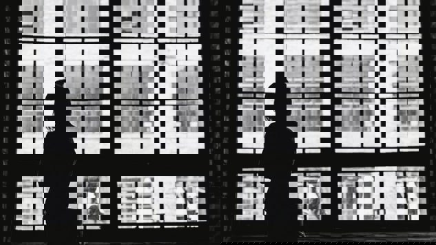 A black and white image of a woman standing by a window. Picture: Unsplash.