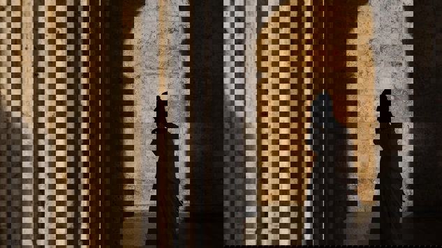 The shadow of a man walking by a stone house. Picture: Unsplash.