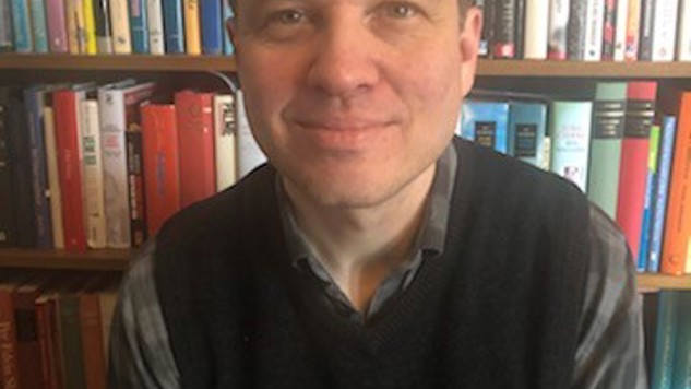 Henrik Malm Lindberg sitting in front of a book shelf.
