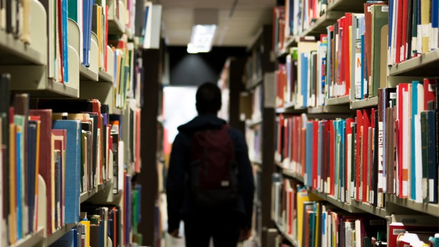 A man with a backpack walking in a library. Picture: Unsplash.